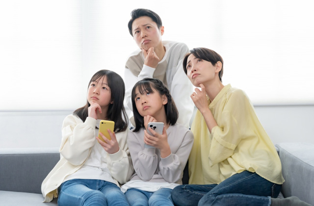 何かを考えている表情の4人家族