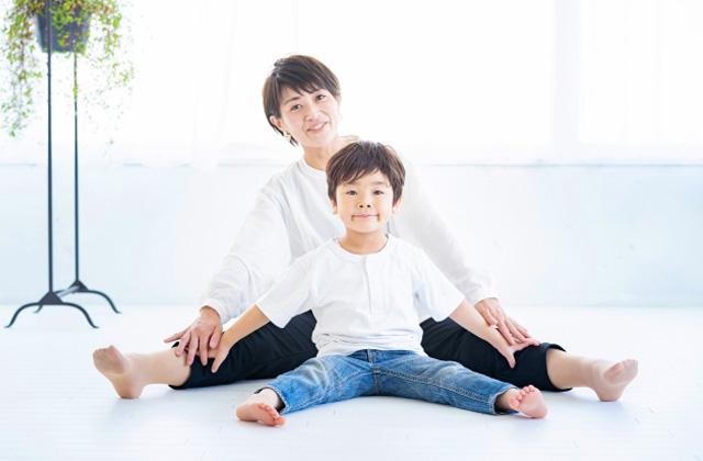 室内で開脚している母親と男の子
