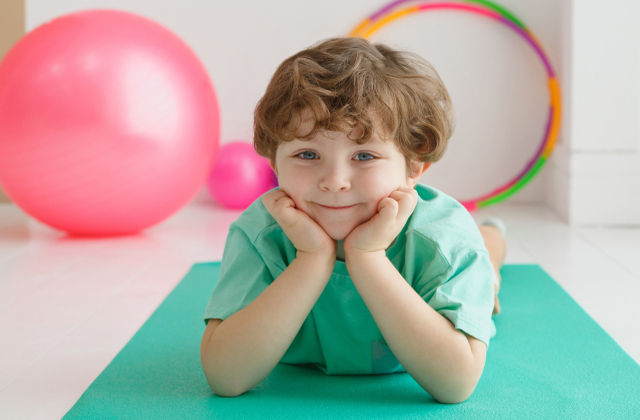 男の子がマットの上でポーズを取ってる