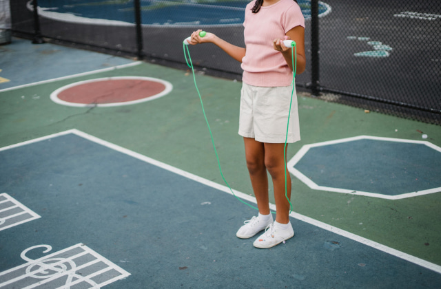 屋外で縄跳びをする子ども