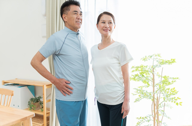 部屋の中で並んで立っている老夫婦